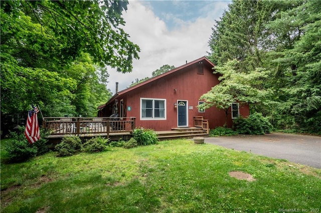 view of front of home with a front lawn and a wooden deck