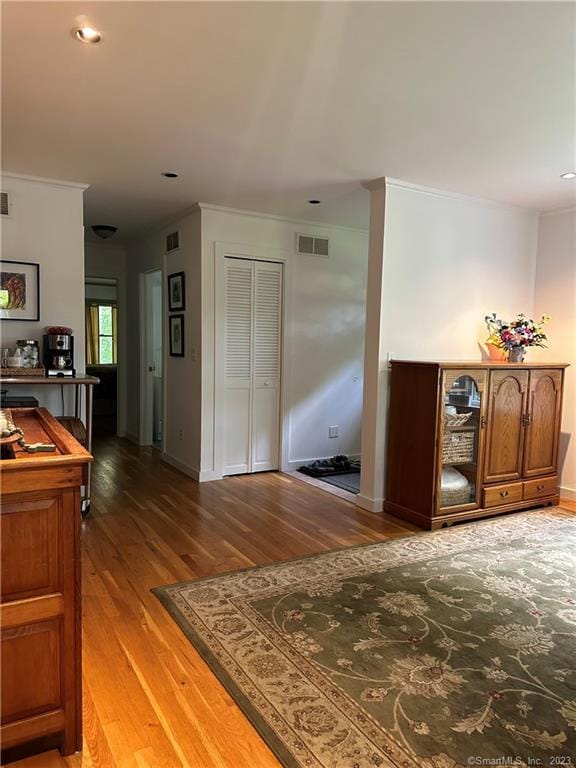 hallway with crown molding and hardwood / wood-style flooring