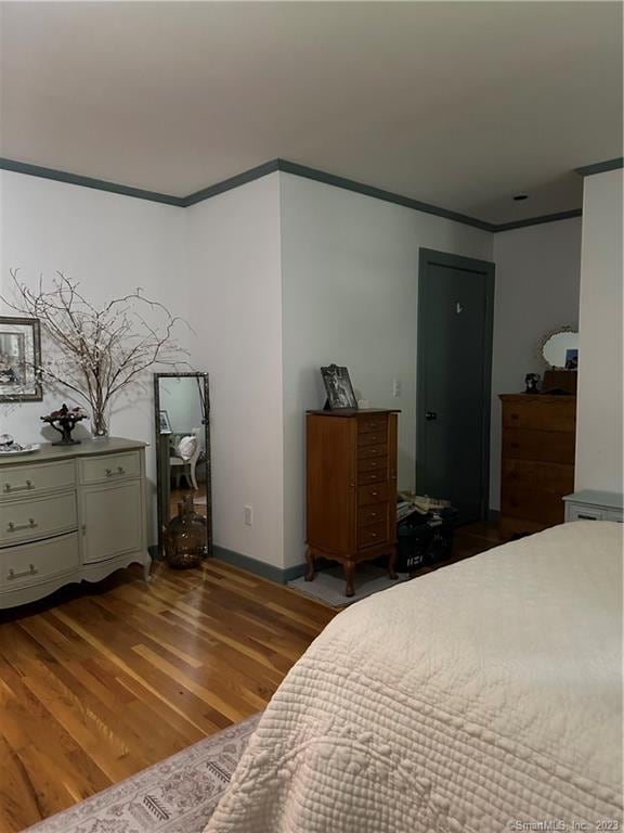 bedroom with crown molding and hardwood / wood-style floors