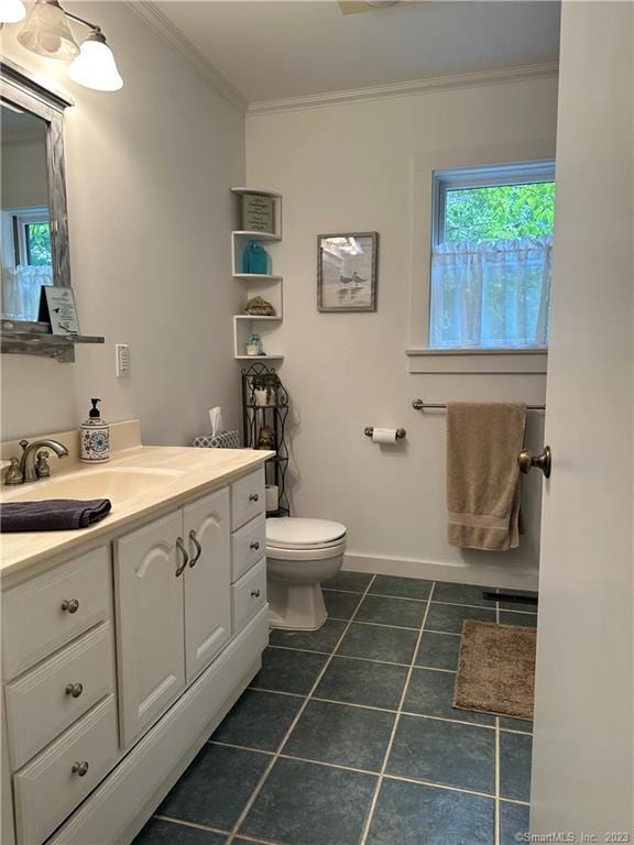 bathroom with tile patterned floors, toilet, ornamental molding, and vanity