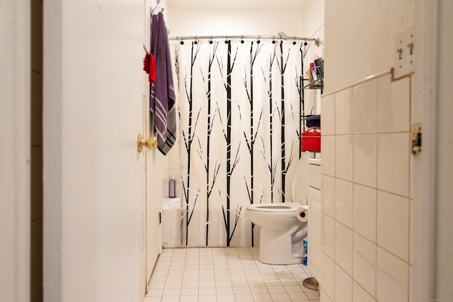 bathroom with curtained shower, toilet, and tile patterned floors