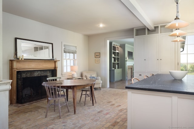 dining room with beamed ceiling and a wealth of natural light