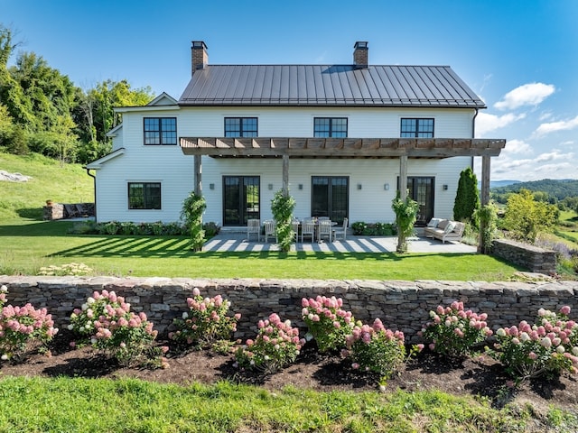 back of property with a yard and a patio area