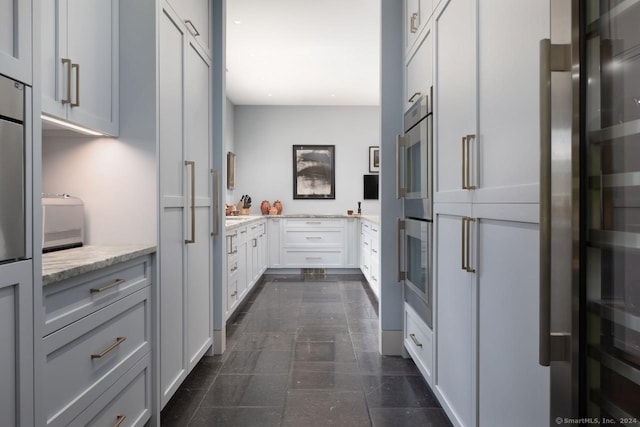 89 Under Mountain Rd, Canaan, CT 06031 - kitchen featuring light stone countertops, double oven, and freestanding refrigerator