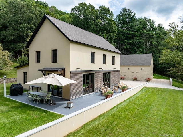 89 Under Mountain Rd, Canaan, CT 06031 - rear view of house with a yard, stucco siding, a shingled roof, and a patio