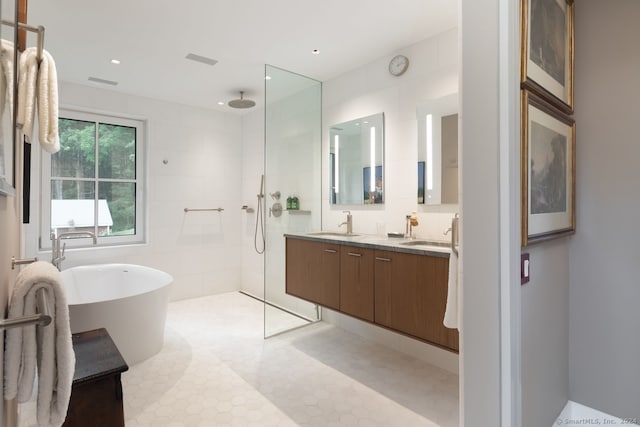 bathroom featuring tile patterned floors, tile walls, independent shower and bath, and vanity