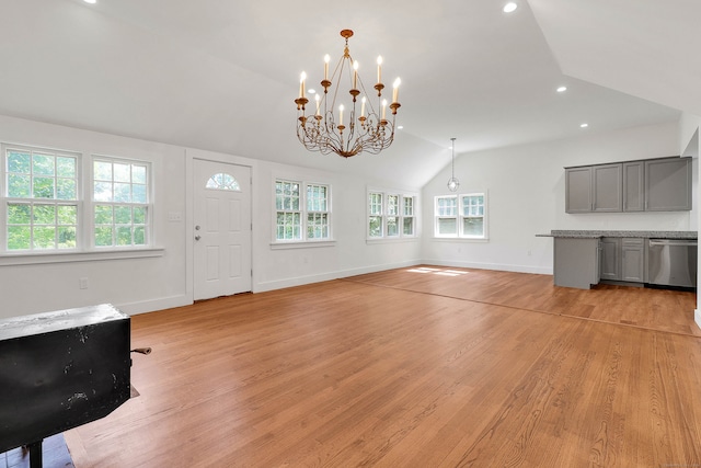 interior space featuring light hardwood / wood-style flooring, vaulted ceiling, a notable chandelier, and plenty of natural light