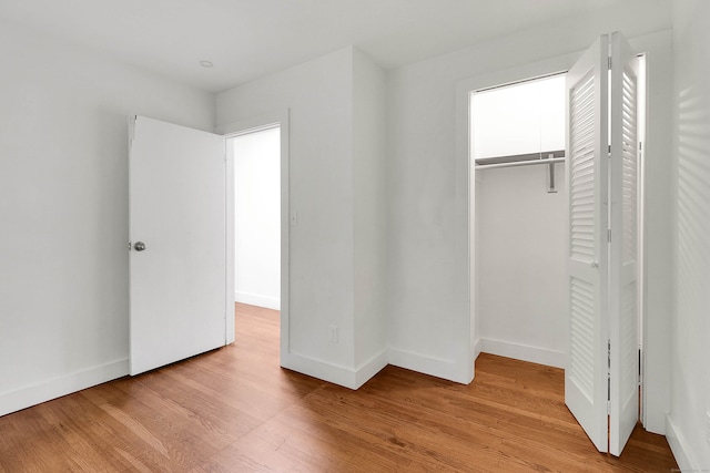 unfurnished bedroom featuring light hardwood / wood-style flooring and a closet