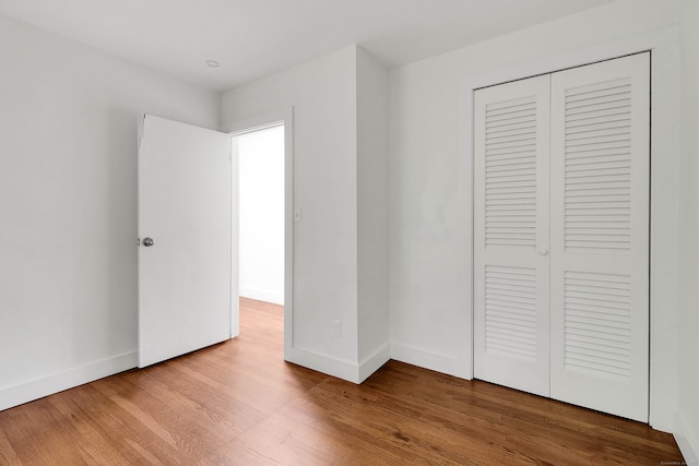 unfurnished bedroom with wood-type flooring and a closet