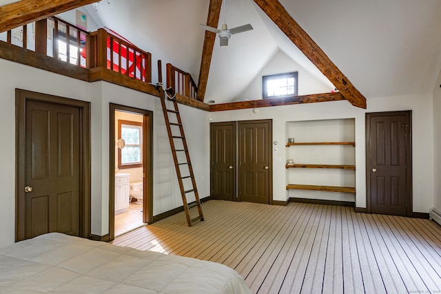 bedroom with beam ceiling, high vaulted ceiling, multiple windows, and ensuite bath