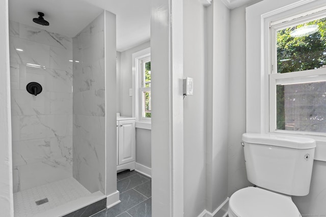 bathroom featuring tile patterned floors, tiled shower, toilet, and a healthy amount of sunlight