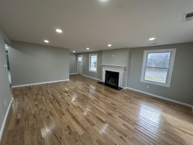 unfurnished living room with light wood-type flooring and plenty of natural light