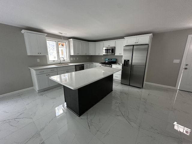 kitchen featuring white cabinetry, sink, a center island, and appliances with stainless steel finishes