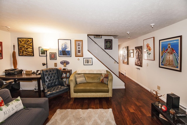 living room with a textured ceiling and dark wood-type flooring