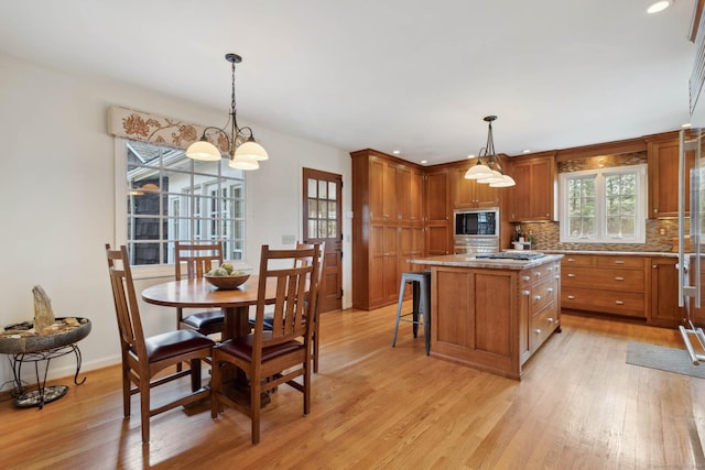 kitchen featuring a breakfast bar area, a kitchen island, decorative light fixtures, and an inviting chandelier