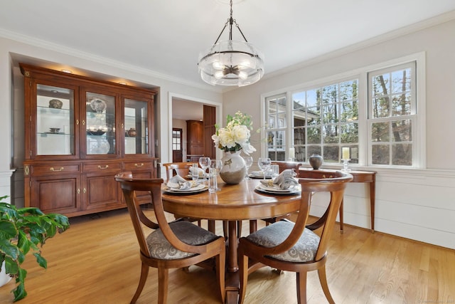 dining room featuring ornamental molding and light wood-type flooring