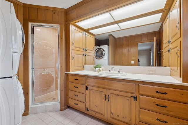 bathroom with vanity, stacked washer and dryer, and wooden walls