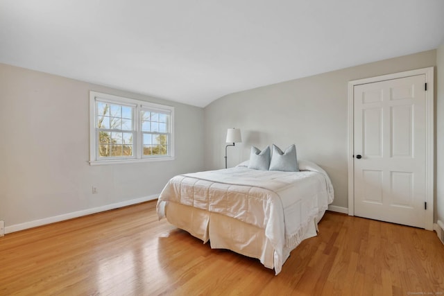 bedroom with light hardwood / wood-style floors and vaulted ceiling