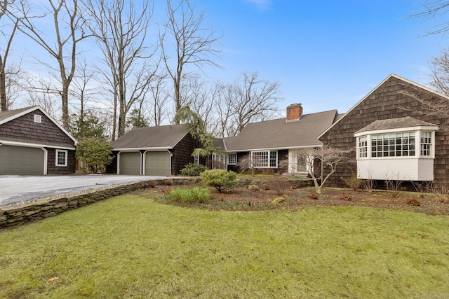 view of front of property with an outbuilding, a front yard, and a garage