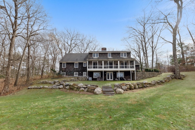 back of property with a sunroom and a yard