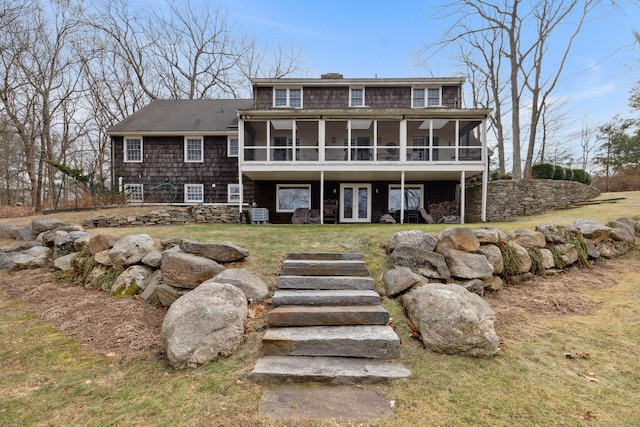 rear view of property featuring a sunroom and a yard