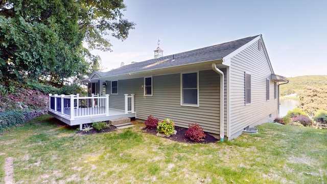 rear view of property featuring a yard and a wooden deck