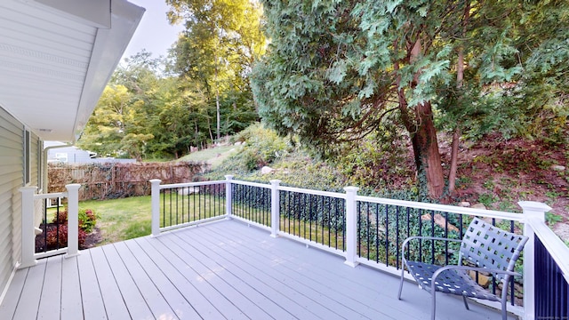 wooden deck with a lawn and fence