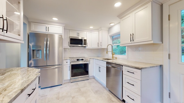 kitchen featuring white cabinets, light stone countertops, sink, and appliances with stainless steel finishes