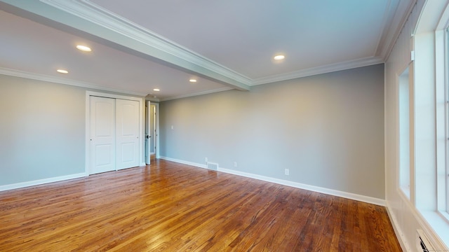 spare room featuring wood-type flooring and ornamental molding