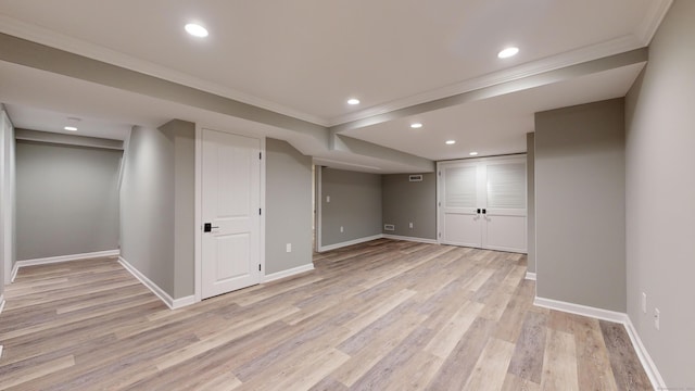 finished basement with light wood-style floors, ornamental molding, baseboards, and recessed lighting