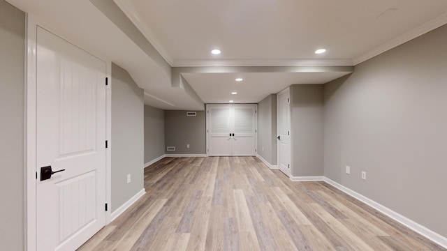 basement with crown molding and light hardwood / wood-style flooring