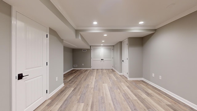 finished below grade area featuring baseboards, ornamental molding, light wood finished floors, and recessed lighting