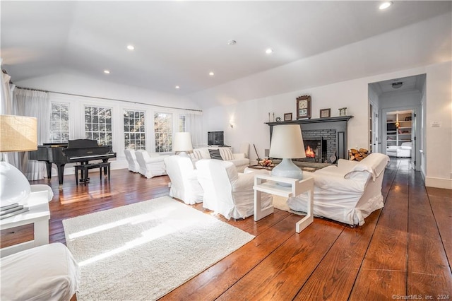 living room featuring a fireplace, lofted ceiling, and hardwood / wood-style flooring