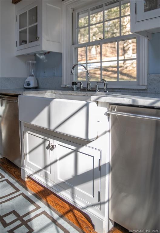 kitchen featuring dishwasher, white cabinetry, and sink