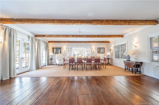 dining space with ornamental molding, beamed ceiling, and light hardwood / wood-style floors