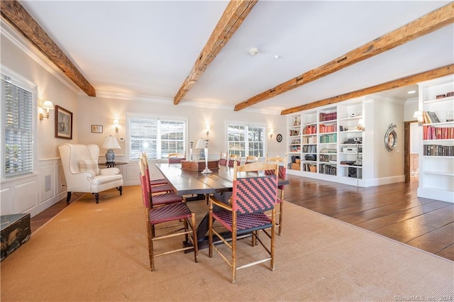 dining room with crown molding, wood-type flooring, and beam ceiling