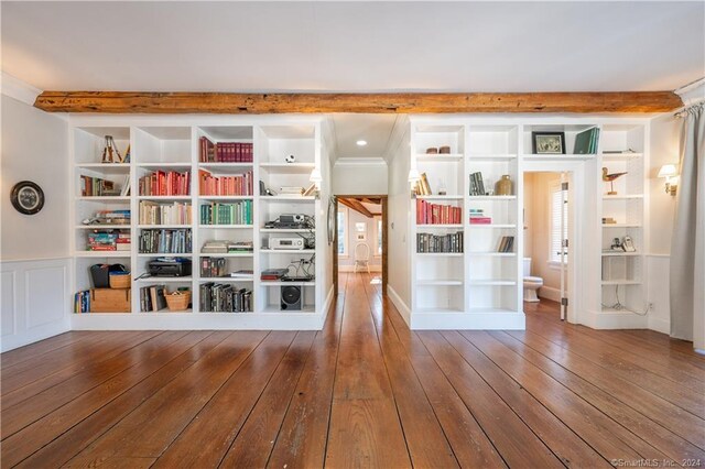 interior space with wood-type flooring, crown molding, and beamed ceiling