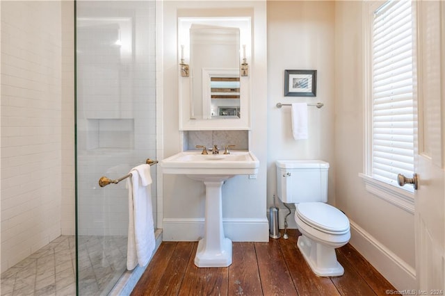 bathroom featuring hardwood / wood-style floors, walk in shower, and toilet