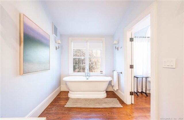 bathroom featuring hardwood / wood-style flooring and a bathing tub