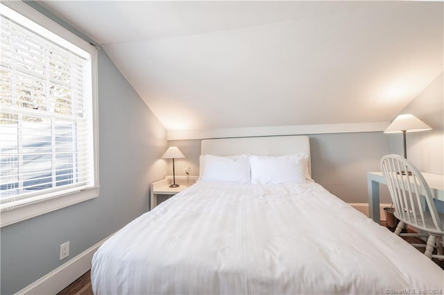 bedroom with lofted ceiling and dark hardwood / wood-style floors