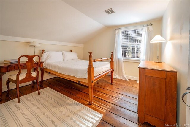 bedroom with lofted ceiling and hardwood / wood-style floors