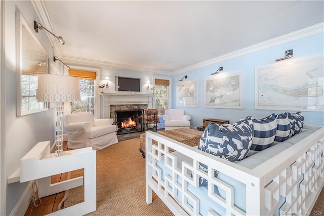 carpeted living room with ornamental molding, a healthy amount of sunlight, and a high end fireplace