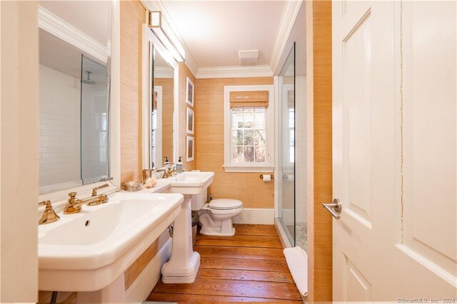 bathroom with crown molding, walk in shower, toilet, sink, and wood-type flooring