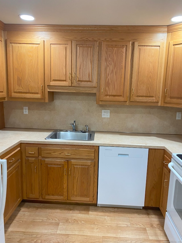 kitchen featuring light hardwood / wood-style floors, sink, white appliances, and tasteful backsplash