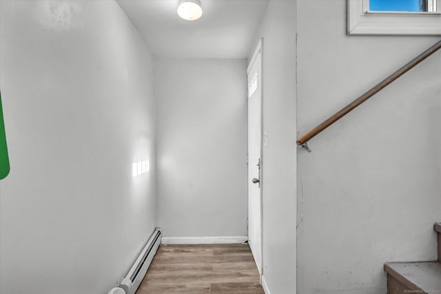 stairs featuring hardwood / wood-style floors and baseboard heating