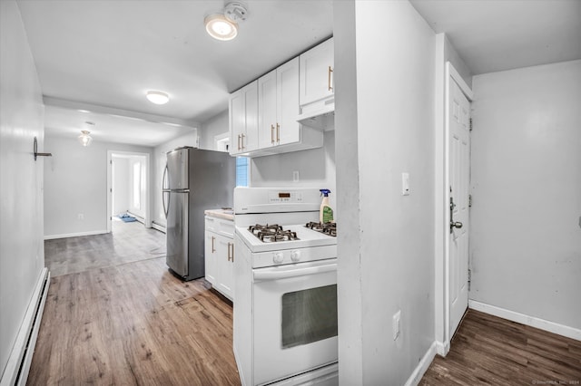 kitchen featuring white gas range, stainless steel refrigerator, light hardwood / wood-style flooring, and white cabinets