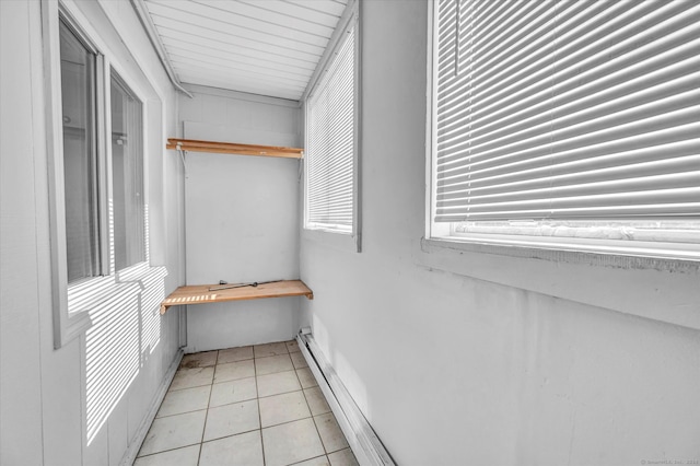 walk in closet with a baseboard heating unit and light tile patterned floors