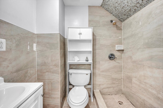 bathroom featuring vanity, toilet, and tiled shower