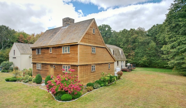 view of property exterior featuring a wooden deck and a lawn