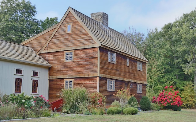 view of side of home with a yard